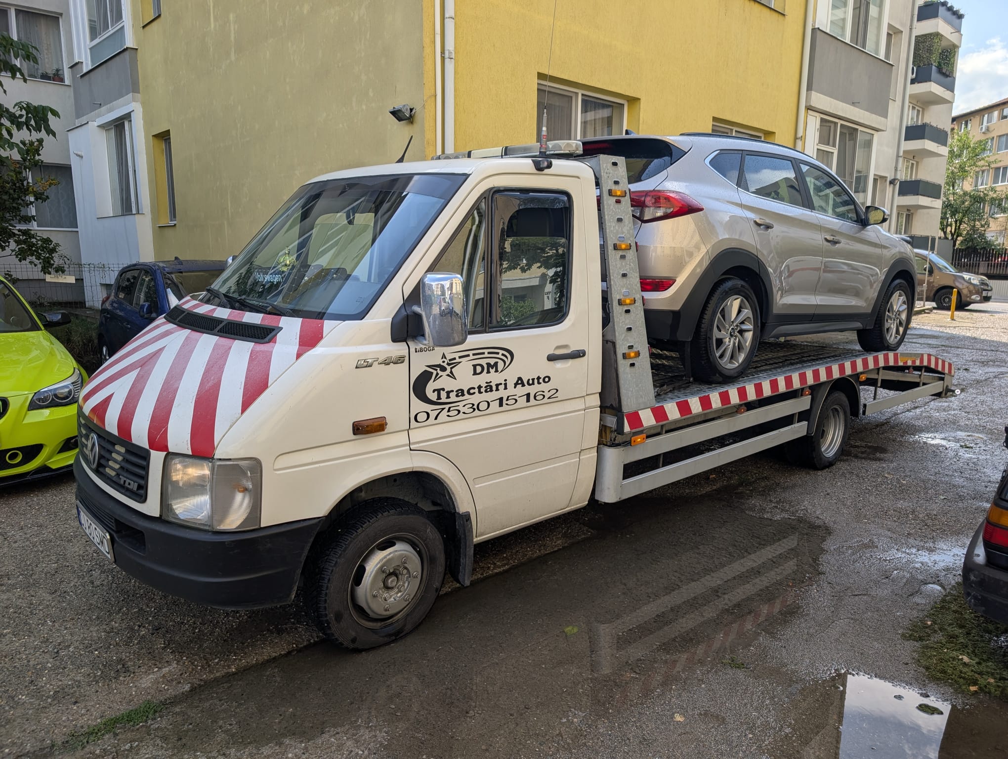 Platformă Alextrans încărcată cu un autoturism în oraș