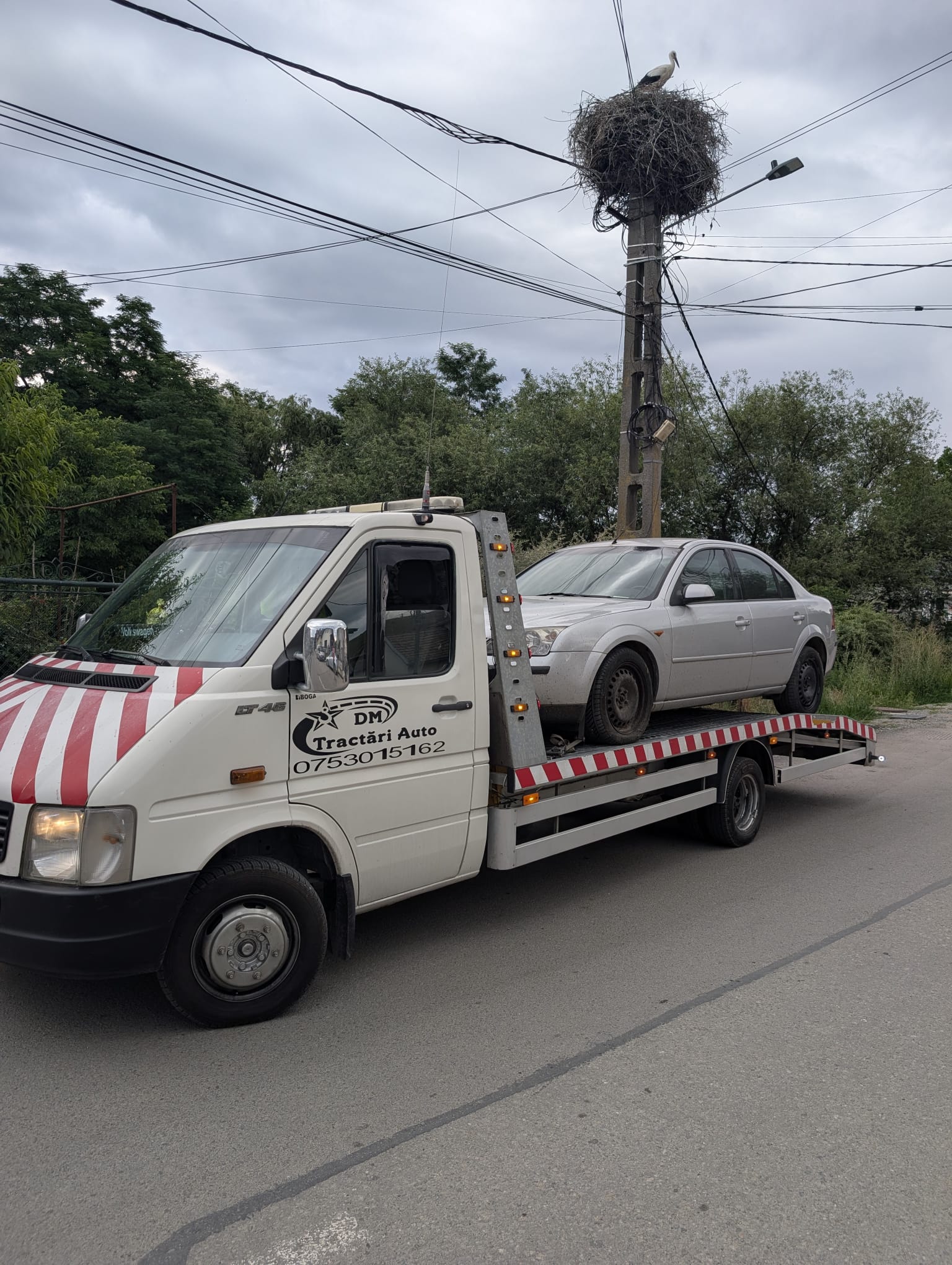 Platformă cu autoturism fotografiată pe drum
