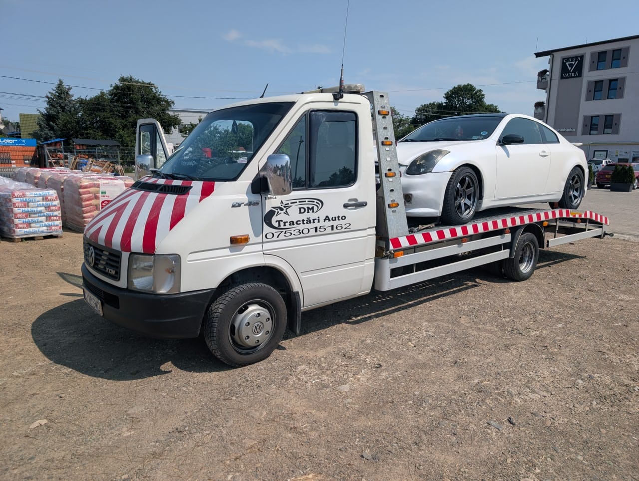 Autoturism alb transportat pe platforma Alextrans