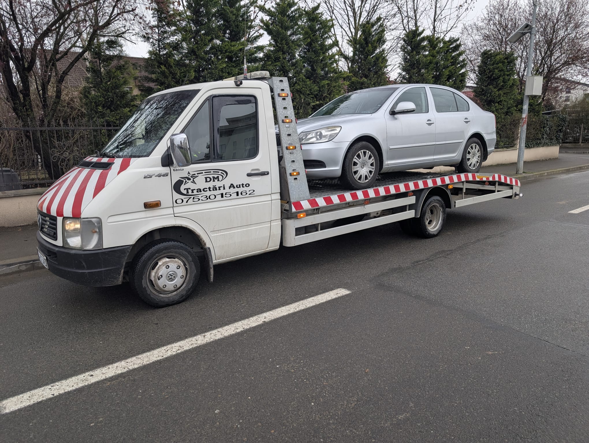 Autospecială Alextrans cu autoturism alb pe platformă